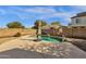 Backyard pool with a basketball hoop and an umbrella, surrounded by tan concrete at 6271 S Twilight Ct, Gilbert, AZ 85298