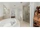 Spacious bathroom featuring a large soaking tub, a glass shower, and a bedroom access at 7175 E Camelback Rd # 1106, Scottsdale, AZ 85251