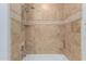 Close-up of a shower featuring neutral-toned tiles and a handheld shower head at 7175 E Camelback Rd # 1106, Scottsdale, AZ 85251