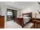 Bright bedroom with a dark wood bed and sliding doors to a balcony with city views at 7175 E Camelback Rd # 1106, Scottsdale, AZ 85251