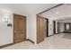 Hallway features a wooden door, and an elevator for convenience, leading to a welcoming, neutral-toned space at 7175 E Camelback Rd # 1106, Scottsdale, AZ 85251