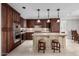 Gourmet kitchen showcasing an island with a granite countertop and seating, and dark wood cabinetry at 7175 E Camelback Rd # 1106, Scottsdale, AZ 85251