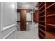 Spacious walk-in closet with dark wood shelves and cabinets for optimal storage at 7175 E Camelback Rd # 1106, Scottsdale, AZ 85251