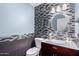 Stylish powder room with blue walls, mosaic tile accent wall, modern vanity, and round mirror at 7500 E Deer Valley Rd # 157, Scottsdale, AZ 85255