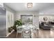 Dining area featuring a round glass table with white chairs, sliding glass doors, and view into the living room at 7500 E Deer Valley Rd # 157, Scottsdale, AZ 85255