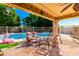 Covered patio with chairs and table overlooking a pool at 7810 W Wescott Dr, Glendale, AZ 85308