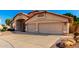 Side angle view of home showing the driveway leading to a two-car garage and desert landscaping at 7810 W Wescott Dr, Glendale, AZ 85308