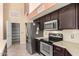 Well-equipped kitchen with stainless steel appliances, pantry and dark wood cabinetry at 7810 W Wescott Dr, Glendale, AZ 85308