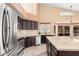 Spacious kitchen featuring stainless steel appliances, granite countertops, and dark wood cabinetry at 7810 W Wescott Dr, Glendale, AZ 85308