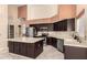 Bright kitchen with stainless steel appliances, dark cabinetry, granite countertops and tile floors at 7810 W Wescott Dr, Glendale, AZ 85308