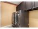 Laundry room with updated, dark cabinets and washer and dryer machines at 7810 W Wescott Dr, Glendale, AZ 85308