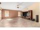 Open-concept living room with tile flooring, a ceiling fan, and a built-in entertainment center at 7810 W Wescott Dr, Glendale, AZ 85308