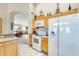 Modern kitchen with an open layout that flows into the dining and living areas, featuring white appliances at 9174 W Marconi Ave, Peoria, AZ 85382