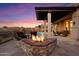 Outdoor patio with a built-in stone fire pit, perfect for enjoying desert views at 9776 E Granite Peak Trl, Scottsdale, AZ 85262