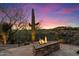 Outdoor patio with a built-in stone fire pit, set against the desert landscape at 9776 E Granite Peak Trl, Scottsdale, AZ 85262