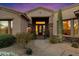 Inviting desert home entrance with a gated courtyard, stone accents, and desert landscaping at 9776 E Granite Peak Trl, Scottsdale, AZ 85262