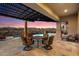 Outdoor patio with sunset views featuring a dining set and sparkling swimming pool at 9776 E Granite Peak Trl, Scottsdale, AZ 85262