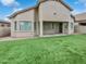 Backyard featuring a covered patio, turf lawn, and neutral stucco exterior at 10320 W Cashman Dr, Peoria, AZ 85383