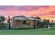 Community amphitheater featuring a stage and a shade canopy, surrounded by grassy lawns and landscaping at sunset at 10617 E Durant Dr, Mesa, AZ 85212