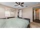 This neutral bedroom features a ceiling fan, carpeted floors, and a large window with natural light at 10617 E Durant Dr, Mesa, AZ 85212