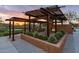 Sunset view of an outdoor community space with a fireplace, seating, and desert landscaping at 10617 E Durant Dr, Mesa, AZ 85212