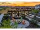 Community fire pit area featuring a pergola, landscaping and colorful Adirondack chairs at 10617 E Durant Dr, Mesa, AZ 85212