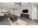 Open living room features dark wood floors, ceiling fan and seamless access to the dining area and kitchen at 10617 E Durant Dr, Mesa, AZ 85212