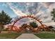 Community playground featuring the Orange Monster play structure with climbing nets, slides and beautiful sunset sky at 10617 E Durant Dr, Mesa, AZ 85212