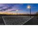 Outdoor sand volleyball court illuminated by lights, set against a colorful evening sky at 10617 E Durant Dr, Mesa, AZ 85212