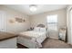 This bedroom offers a queen bed with a white upholstered headboard, plush blanket, and neutral walls at 10816 W Nosean Rd, Peoria, AZ 85383