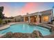 Backyard featuring pool with rock features, desert landscaping, and covered patio at 11322 N 118Th Way, Scottsdale, AZ 85259