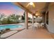 Covered backyard patio featuring a pool with rock features and mountain views at 11322 N 118Th Way, Scottsdale, AZ 85259