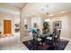 Elegant dining area with a glass-top table, stylish chairs, and an open view into the living room at 11322 N 118Th Way, Scottsdale, AZ 85259