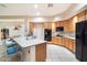 Bright kitchen area has a large breakfast bar, black appliances, and neutral tile flooring at 11322 N 118Th Way, Scottsdale, AZ 85259