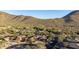 Scenic aerial view of a desert community nestled amongst lush landscaping and mountains at 11496 E Pine Valley Rd, Scottsdale, AZ 85255