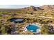 Aerial view of community featuring pool, tennis courts, and mountain views at 11496 E Pine Valley Rd, Scottsdale, AZ 85255