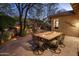 Outdoor dining on a back patio with stone pavers and a built-in grill at 11496 E Pine Valley Rd, Scottsdale, AZ 85255