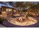 Inviting backyard with a stone fire pit, mature trees, and outdoor seating, perfect for entertaining at 11496 E Pine Valley Rd, Scottsdale, AZ 85255