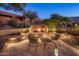 Outdoor fireplace with stone surround, set in landscaped backyard at 11496 E Pine Valley Rd, Scottsdale, AZ 85255