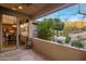 Inviting covered patio with desert landscaping and views of the kitchen through glass doors at 11496 E Pine Valley Rd, Scottsdale, AZ 85255