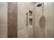 Modern shower with decorative tile, shelving niche and grab bar at 11496 E Pine Valley Rd, Scottsdale, AZ 85255