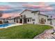 Expansive backyard with a pool, covered patio, lush green lawn, and beautiful landscaping at 1252 N Jackson St, Gilbert, AZ 85233