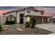 Inviting home exterior showcasing desert landscaping, arched entry, and three car garage at 1252 N Jackson St, Gilbert, AZ 85233