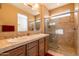 Bathroom featuring double sinks, decorative framed mirror and backsplash, and a glass walk-in shower at 13070 W Eagle Talon Trl, Peoria, AZ 85383