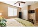 Bedroom showcasing neutral colors, a ceiling fan, a shuttered window, and a large wall-mounted TV at 13070 W Eagle Talon Trl, Peoria, AZ 85383