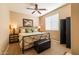 Light and airy bedroom featuring a ceiling fan, shuttered window, and dark wood furnishings at 13070 W Eagle Talon Trl, Peoria, AZ 85383