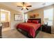 Comfortable bedroom with a ceiling fan, neutral color scheme, and natural light from shuttered windows at 13070 W Eagle Talon Trl, Peoria, AZ 85383