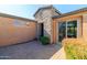 Stylish courtyard entrance featuring a stone facade, brick pavers, and mature landscaping at 13070 W Eagle Talon Trl, Peoria, AZ 85383