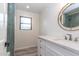 Bright bathroom featuring a round mirror, white vanity, modern finishes, and natural light at 1327 W Glendale Ave, Phoenix, AZ 85021