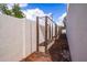 View of garden beds in a sunny backyard with a white wall and wooden supports at 1327 W Glendale Ave, Phoenix, AZ 85021